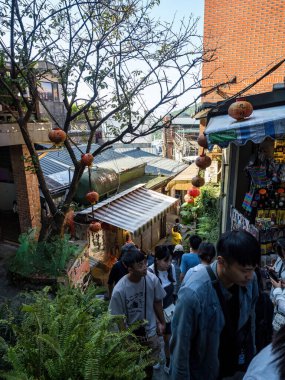 YENİ TAIPEI TAIWAN - 27 Ağustos 2024: Gezen ve alışveriş yapan turistlerle Jiufen eski caddesi. Geleneksel Çin fenerleri dar sokaklar boyunca asılı. Taipei yakınlarında popüler bir seyahat merkezidir..