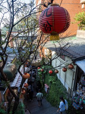 YENİ TAIPEI TAIWAN - 27 Ağustos 2024: Gezen ve alışveriş yapan turistlerle Jiufen eski caddesi. Geleneksel Çin fenerleri dar sokaklar boyunca asılı. Taipei yakınlarında popüler bir seyahat merkezidir..