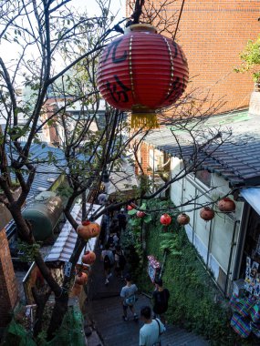 YENİ TAIPEI TAIWAN - 27 Ağustos 2024: Gezen ve alışveriş yapan turistlerle Jiufen eski caddesi. Geleneksel Çin fenerleri dar sokaklar boyunca asılı. Taipei yakınlarında popüler bir seyahat merkezidir..