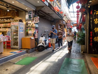 YENİ TAIPEI TAIWAN - 27 Ağustos 2024: Gezen ve alışveriş yapan turistlerle Jiufen eski caddesi. Geleneksel Çin fenerleri dar sokaklar boyunca asılı. Taipei yakınlarında popüler bir seyahat merkezidir..