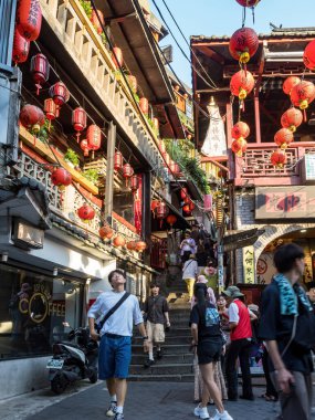 YENİ TAIPEI TAIWAN - 27 Ağustos 2024: Gezen ve alışveriş yapan turistlerle Jiufen eski caddesi. Geleneksel Çin fenerleri dar sokaklar boyunca asılı. Taipei yakınlarında popüler bir seyahat merkezidir..