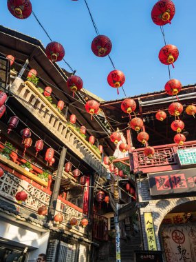 YENİ TAIPEI TAIWAN - 27 Ağustos 2024: Gezen ve alışveriş yapan turistlerle Jiufen eski caddesi. Geleneksel Çin fenerleri dar sokaklar boyunca asılı. Taipei yakınlarında popüler bir seyahat merkezidir..