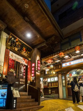 YENİ TAIPEI TAIWAN - 27 Ağustos 2024: Gezen ve alışveriş yapan turistlerle Jiufen eski caddesi. Geleneksel Çin fenerleri dar sokaklar boyunca asılı. Taipei yakınlarında popüler bir seyahat merkezidir..