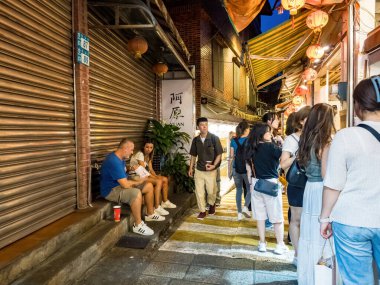 NEW TAIPEI TAIWAN - August 27 ,2024 :Jiufen old street with tourists walking and shopping. Traditional chinese lanterns hanging along the narrow street.It is a popular travel destination near Taipei. clipart