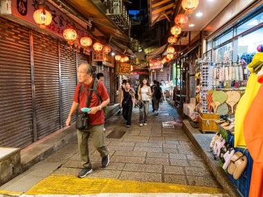 YENİ TAIPEI TAIWAN - 27 Ağustos 2024: Gezen ve alışveriş yapan turistlerle Jiufen eski caddesi. Geleneksel Çin fenerleri dar sokaklar boyunca asılı. Taipei yakınlarında popüler bir seyahat merkezidir..