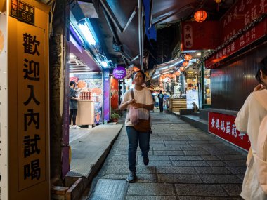 YENİ TAIPEI TAIWAN - 27 Ağustos 2024: Gezen ve alışveriş yapan turistlerle Jiufen eski caddesi. Geleneksel Çin fenerleri dar sokaklar boyunca asılı. Taipei yakınlarında popüler bir seyahat merkezidir..