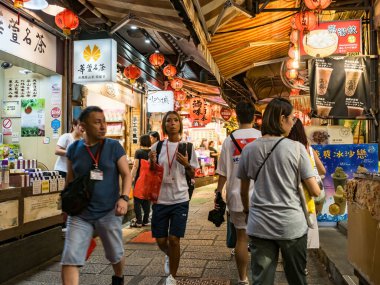 YENİ TAIPEI TAIWAN - 27 Ağustos 2024: Gezen ve alışveriş yapan turistlerle Jiufen eski caddesi. Geleneksel Çin fenerleri dar sokaklar boyunca asılı. Taipei yakınlarında popüler bir seyahat merkezidir..