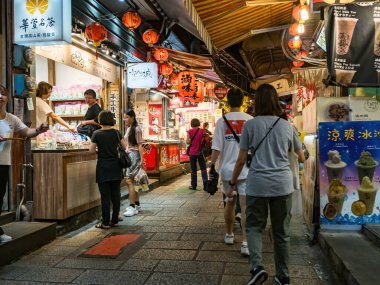 YENİ TAIPEI TAIWAN - 27 Ağustos 2024: Gezen ve alışveriş yapan turistlerle Jiufen eski caddesi. Geleneksel Çin fenerleri dar sokaklar boyunca asılı. Taipei yakınlarında popüler bir seyahat merkezidir..