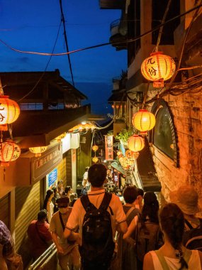 YENİ TAIPEI TAIWAN - 27 Ağustos 2024: Gezen ve alışveriş yapan turistlerle Jiufen eski caddesi. Geleneksel Çin fenerleri dar sokaklar boyunca asılı. Taipei yakınlarında popüler bir seyahat merkezidir..