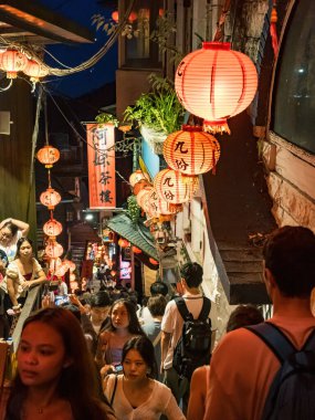 YENİ TAIPEI TAIWAN - 27 Ağustos 2024: Gezen ve alışveriş yapan turistlerle Jiufen eski caddesi. Geleneksel Çin fenerleri dar sokaklar boyunca asılı. Taipei yakınlarında popüler bir seyahat merkezidir..