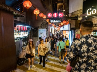 YENİ TAIPEI TAIWAN - 27 Ağustos 2024: Gezen ve alışveriş yapan turistlerle Jiufen eski caddesi. Geleneksel Çin fenerleri dar sokaklar boyunca asılı. Taipei yakınlarında popüler bir seyahat merkezidir..