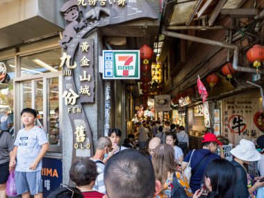 YENİ TAIPEI TAIWAN - 27 Ağustos 2024: Gezen ve alışveriş yapan turistlerle Jiufen eski caddesi. Geleneksel Çin fenerleri dar sokaklar boyunca asılı. Taipei yakınlarında popüler bir seyahat merkezidir..