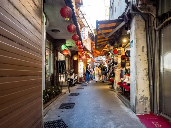 YENİ TAIPEI TAIWAN - 27 Ağustos 2024: Gezen ve alışveriş yapan turistlerle Jiufen eski caddesi. Geleneksel Çin fenerleri dar sokaklar boyunca asılı. Taipei yakınlarında popüler bir seyahat merkezidir..