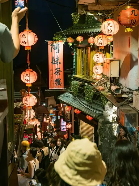 YENİ TAIPEI TAIWAN - 27 Ağustos 2024: Gezen ve alışveriş yapan turistlerle Jiufen eski caddesi. Geleneksel Çin fenerleri dar sokaklar boyunca asılı. Taipei yakınlarında popüler bir seyahat merkezidir..