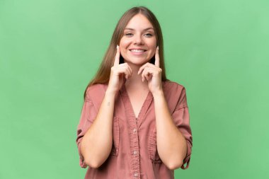 Genç, güzel, sarışın, soyutlanmış, mutlu ve hoş bir ifadeyle gülümseyen bir kadın.