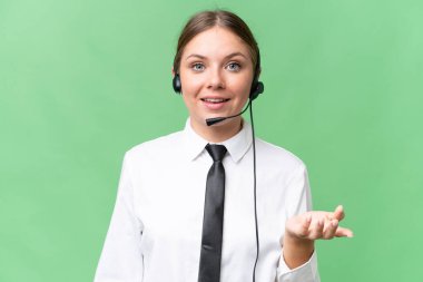 Tele pazarlamacı beyaz kadın izole edilmiş arka planda kulaklıkla çalışıyor ve şok olmuş yüz ifadesi var.