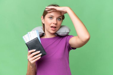 Şişirilebilir seyahat yastığı olan genç, güzel sarışın bir kadın izole edilmiş arka planda sürpriz jest yapıyor.