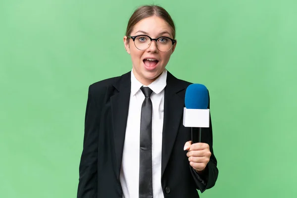 Young TV presenter caucasian woman  over isolated background with surprise and shocked facial expression