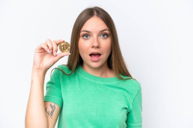 Beyaz zemin üzerinde Bitcoin tutan güzel sarışın kadın şaşırmış ve şok olmuş yüz ifadesi ile izole edilmiş.