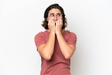 Beyaz arka planda izole edilmiş genç, gergin ve korkmuş bir adam elleriyle suni teneffüs yapıyor