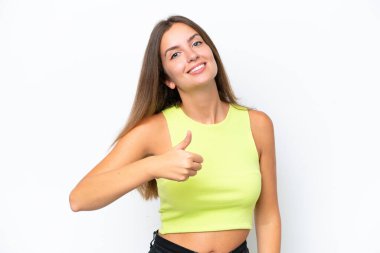 Beyaz arka planda izole edilmiş genç beyaz bir kadın baş parmak hareketi yapıyor.