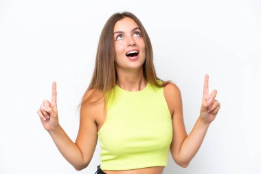 Beyaz arka planda izole edilmiş genç beyaz kadın şaşırmış ve yukarı bakıyor.