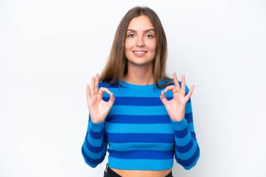 Beyaz arka planda izole edilmiş beyaz bir kadın iki eliyle tamam işareti gösteriyor.