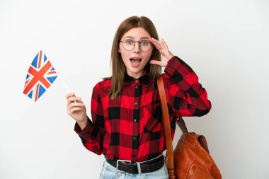 Mavi arka planda Birleşik Krallık bayrağı taşıyan genç bir kadın sürpriz bir ifadeyle izole edildi