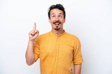 Bıyıklı genç adam beyaz arka planda izole edilmiş yukarı bakıyor ve şaşırıyor.