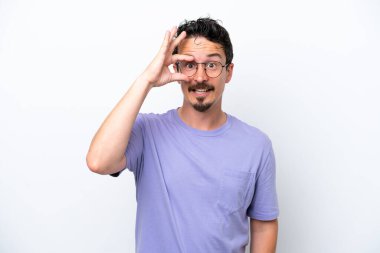 Bıyıklı genç adam beyaz arka planda izole edilmiş. Parmaklarıyla işaret veriyor.