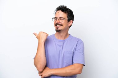 Young man with moustache isolated on white background pointing to the side to present a product