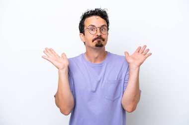 Bıyıklı genç adam beyaz arka planda şüpheli hareketler yapıyor.