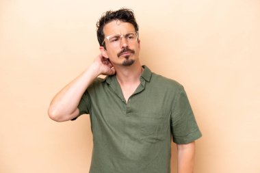 Beyazlı genç bir adam bej arka planda izole edilmiş. Şüpheleri var.