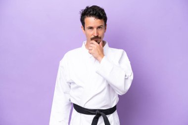 Mor arka planda karate yapan genç beyaz bir adam...