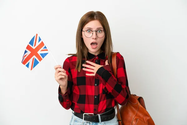 拿着英国国旗 身披蓝色背景的年轻女子 看着右边 感到惊讶和震惊 — 图库照片