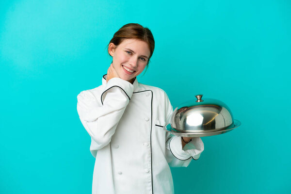 Young chef woman with tray isolated on blue background laughing