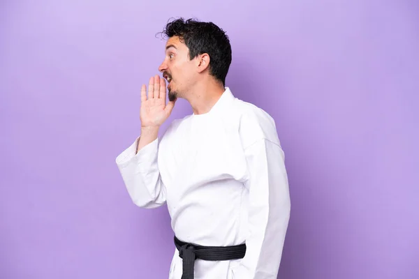 Joven Hombre Caucásico Haciendo Karate Aislado Sobre Fondo Púrpura Gritando —  Fotos de Stock