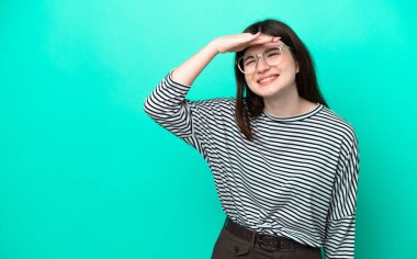 Genç Rus kadın, yeşil arka planda izole edilmiş. Bir şeye bakmak için uzaklara bakıyor.