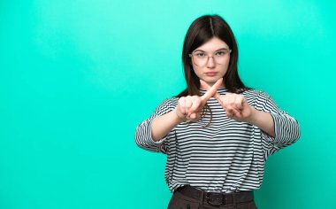 Yeşil arka planda izole edilmiş genç bir Rus kadın bir eylemi durdurmak için eliyle jest yapıyor.