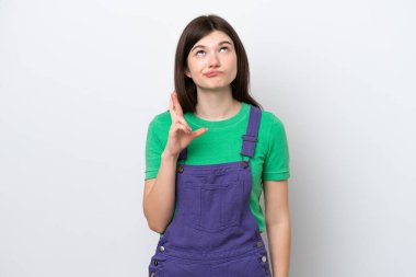 Genç Rus kadın mavi arka planda izole edilmiş, şans diliyor ve en iyisini diliyor.