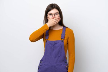 Genç Rus kadın mavi arka planda izole edilmiş. Ağzını eliyle kapatıyor.