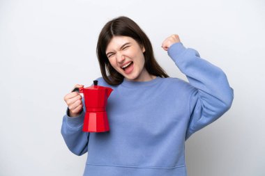 Beyaz arka planda kahve demliği tutan genç Rus kadın zaferi kutluyor.