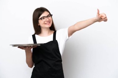Tepsisi beyaz arka planda izole edilmiş genç Rus kadın aşçı baş parmak hareketi yapıyor.