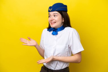 Airplane stewardess Russian woman isolated on yellow background with surprise facial expression