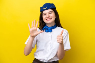 Uçak hostesi Rus kadın sarı arka planda izole edilmiş. Parmakları olan altı kişi saydım.