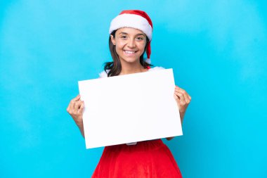 Anne Noel gibi giyinmiş genç İspanyol kadın beyaz arka planda izole edilmiş, elinde mutlu bir ifadeyle boş bir levha tutuyor.