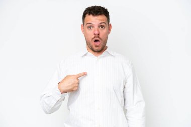 Beyaz arka planda soyutlanmış beyaz tenli yakışıklı bir adam kendini işaret ediyor.