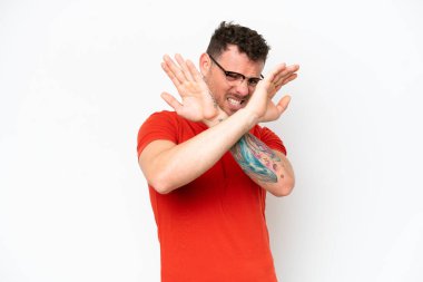 Beyaz arka planda soyutlanmış beyaz tenli yakışıklı adam ellerini öne uzatıyor.