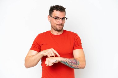 Beyaz arka planda izole genç beyaz yakışıklı adam geç kalma jesti yapıyor