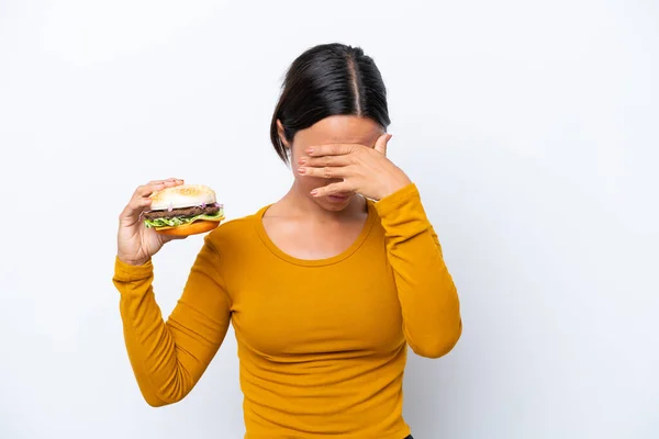 Mladá Hispánka Drží Burger Izolovaný Bílém Pozadí Unaveným Nemocným Výrazem — Stock fotografie